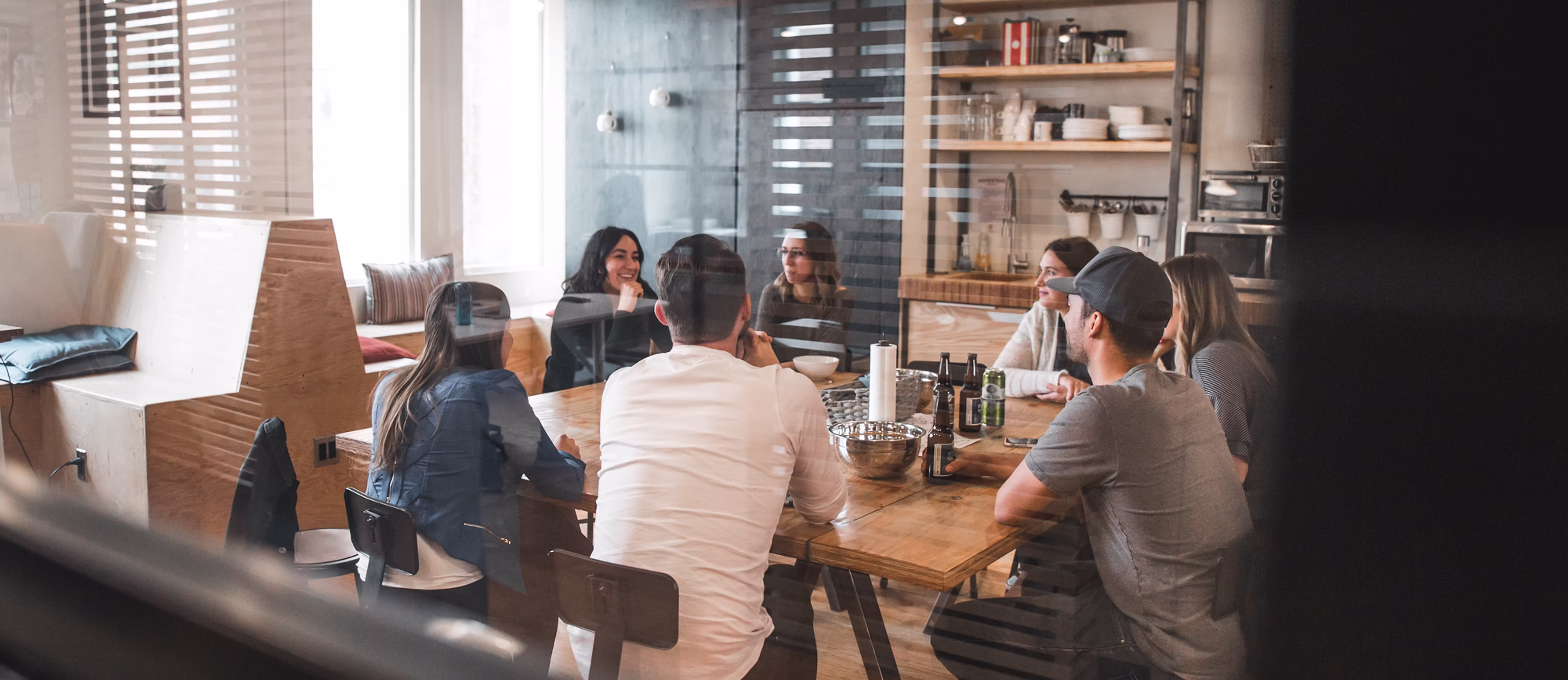 People collaborating around a shared table in a light-filled workspace