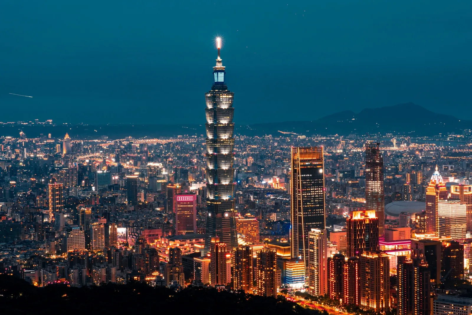The Taipei skyline at night with Taipei 101 lit above the city.
